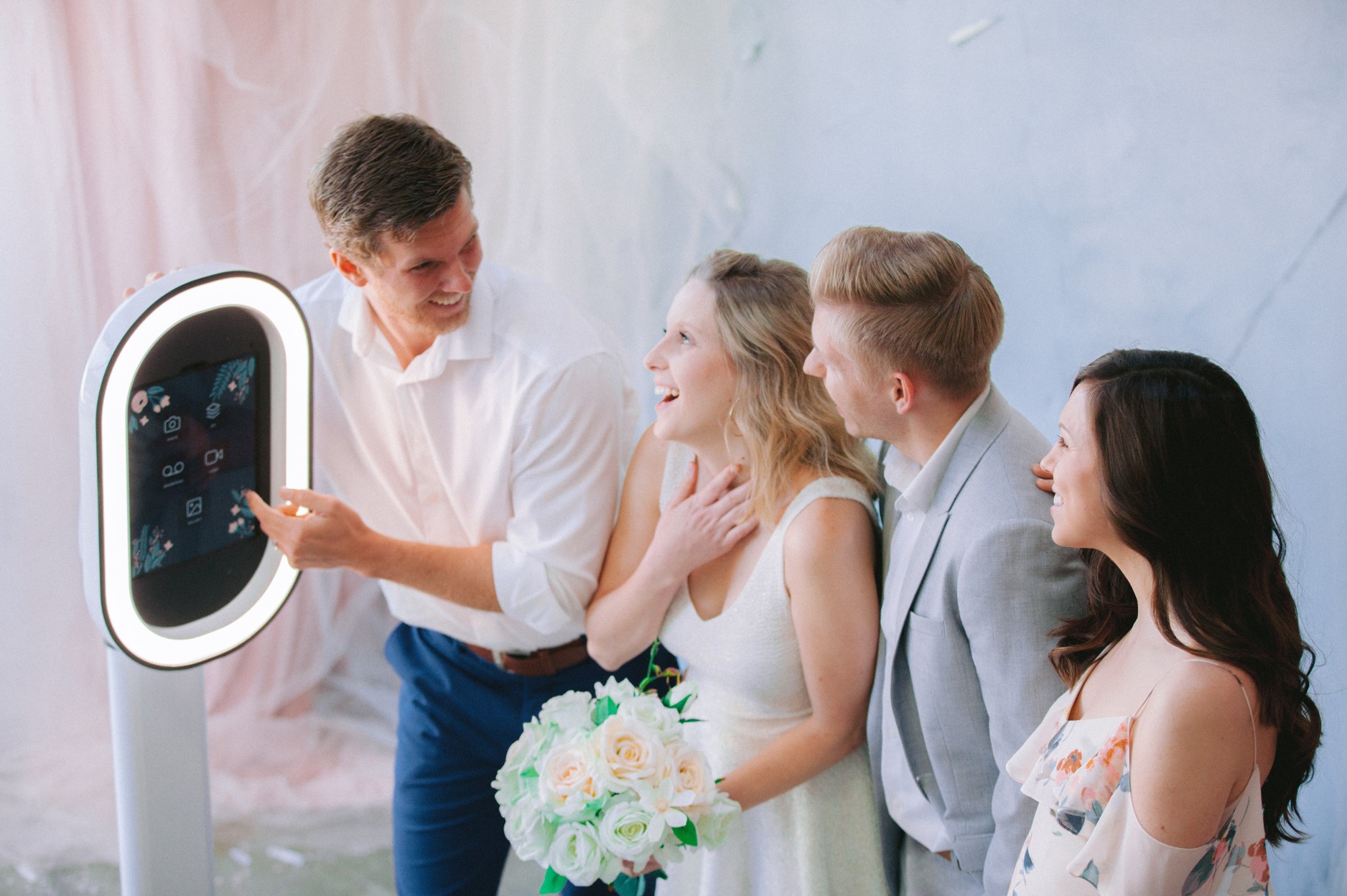 Bruidspaar gebruikt lachend de photobooth op hun trouwdag